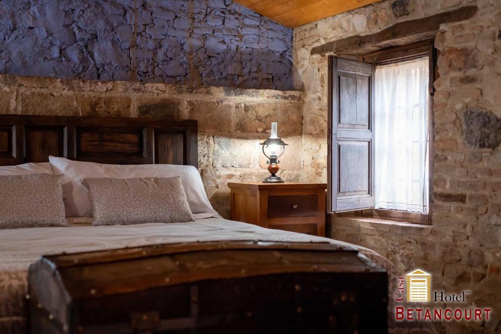 a bedroom with a bed and a window at Hotel Casa Rural Betancourt in Almadén