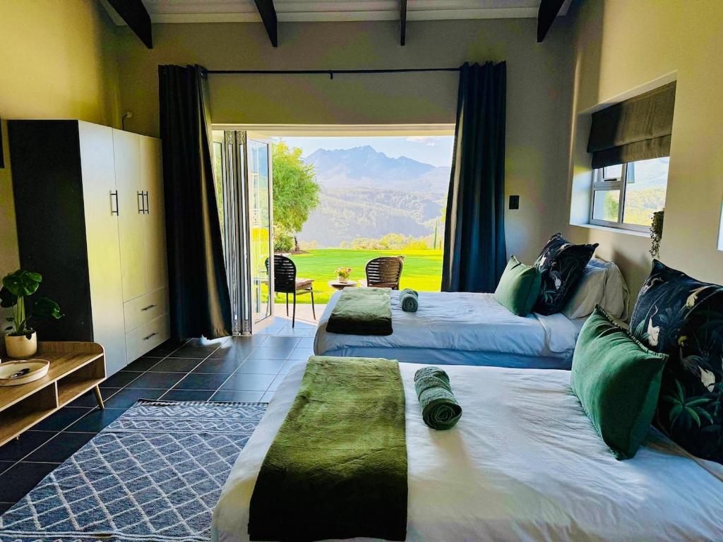 una camera da letto con due letti e una grande finestra di Mountain View Cottage a Wildernis