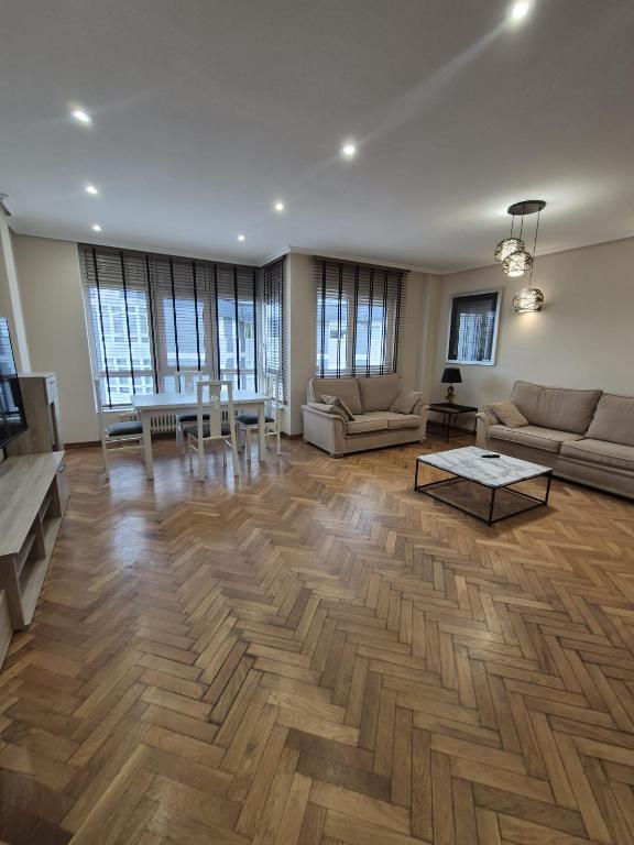 a large living room with a table and couches at Alfonso X Lucus Confort in Lugo
