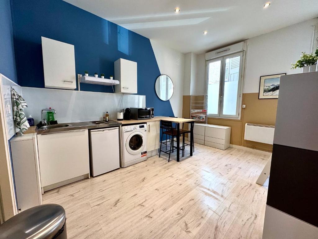une cuisine avec un lave-linge et une table. dans l'établissement Abel & Octave - Gare - St Bruno, à Grenoble