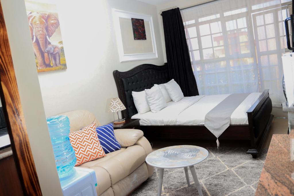 a living room with a bed and a couch at Affordable Luxury Ruaka in Ruaka