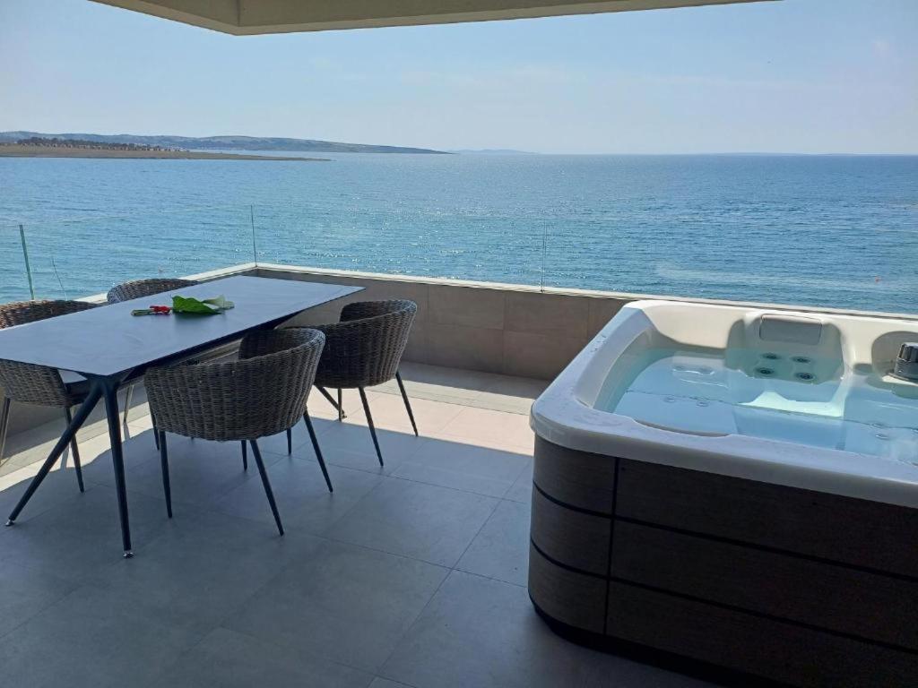 a hot tub on a balcony with a table and chairs at NEW Sunset Suite in Povljana