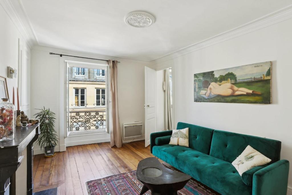 un salon avec un canapé vert et une fenêtre dans l'établissement BnBNova - 2BR - Le Marais & Les Halles, à Paris