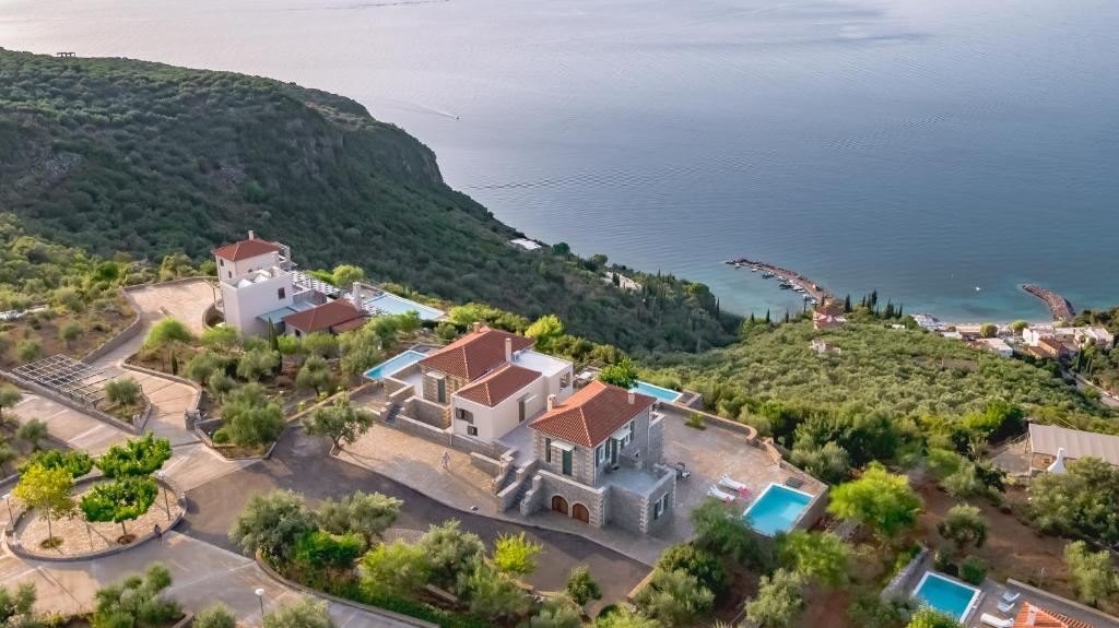 an aerial view of a house on a hill next to the water at Searocks Exclusive Village in Kalamata
