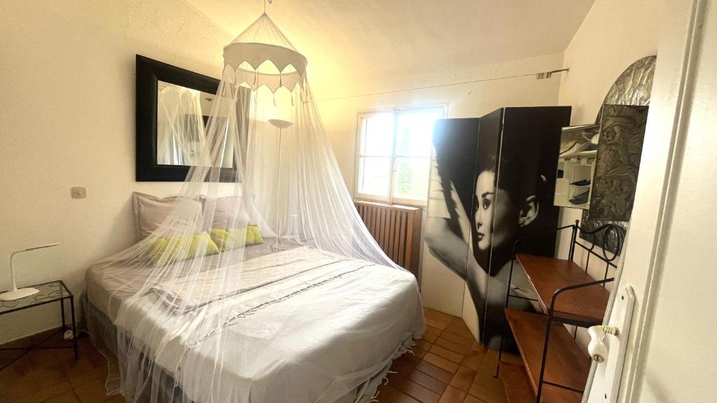 une chambre avec un lit avec moustiquaire dans l'établissement Ferienwohnung My-Port-Grimaud, à Grimaud