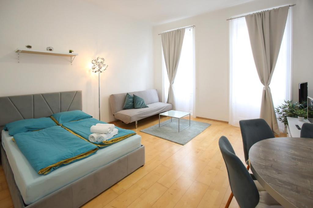 a living room with a bed and a table at Downtown Bliss Modern Retreat with FREE parking and FAST Internet 600 MBits in Vienna