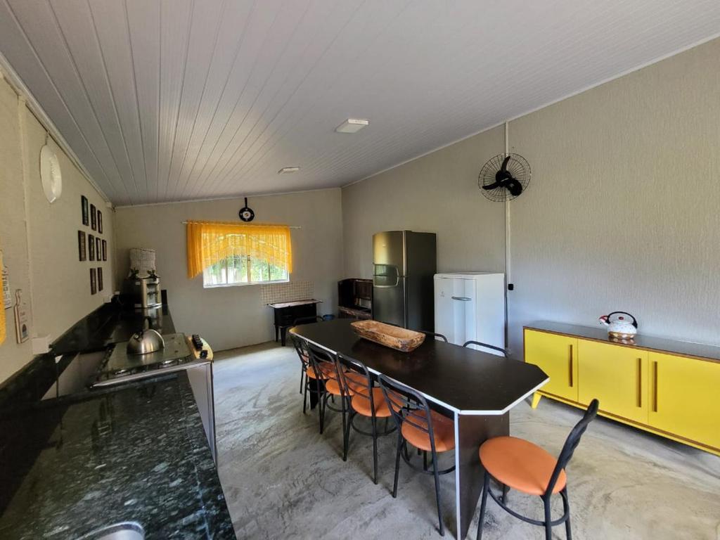 a kitchen with a table and chairs in a room at Rancho Bertotti in Guaratuba