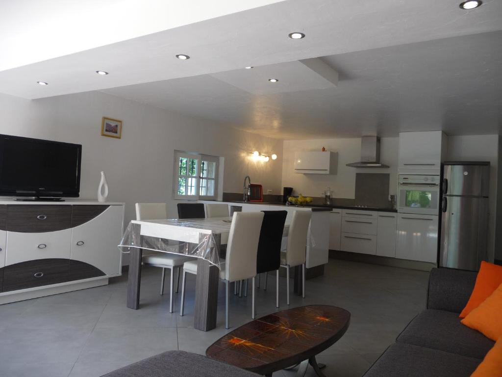 a kitchen and living room with a table and a couch at Appartement Castagniers in Castagniers