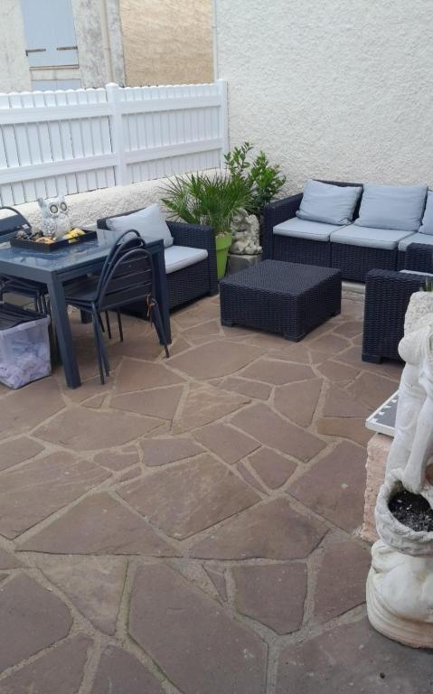 une terrasse avec des canapés, une table et des chaises dans l'établissement Maison village occitan accès direct à la plage, au Cap d'Agde