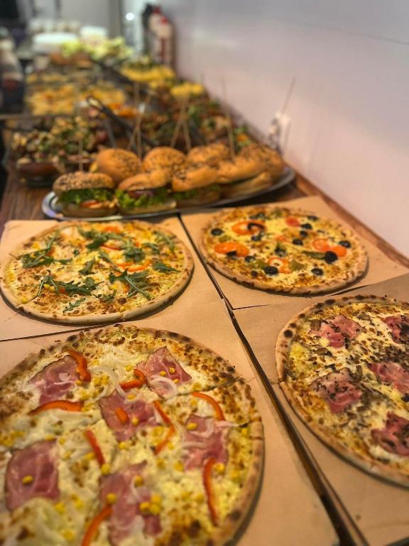 a bunch of pizzas sitting on a table at Greg&Tom Beer House Hostel in Krakow
