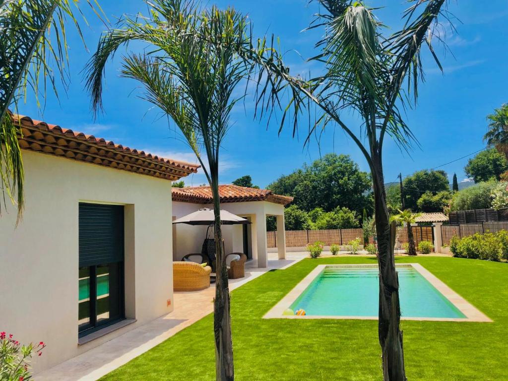 une villa avec piscine et palmiers dans l'établissement La villa Diya, au Plan-de-la-Tour