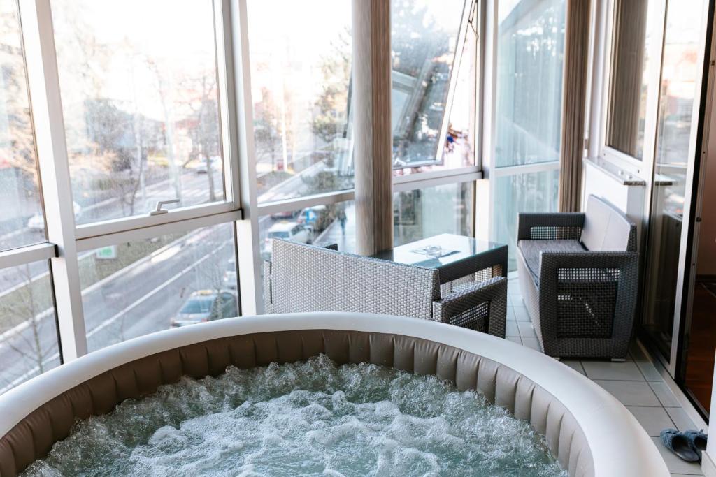 a hot tub in a room with a large window at Stan na dan Kvadar in Brčko