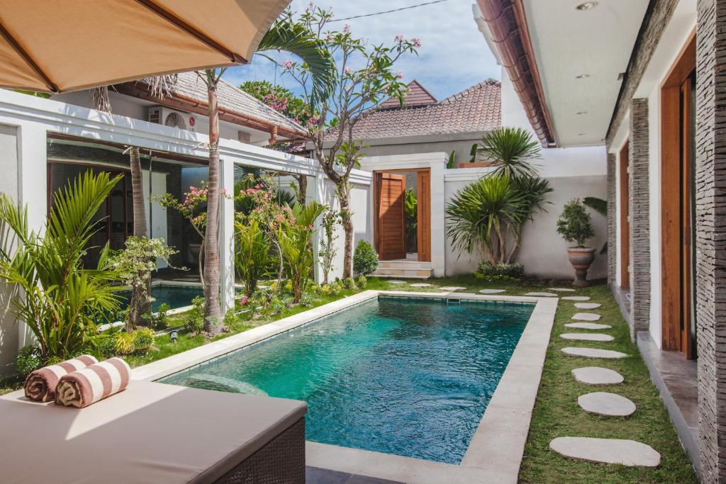 a swimming pool in the backyard of a house at Two Lizards Beach Villas in Sanur