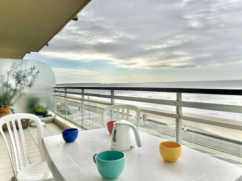 - une table sur un balcon avec vue sur l'océan dans l'établissement Appartement spacieux avec terrasse face mer - 2 pièces, 4 couchages à La Baule - FR-1-245-80, à La Baule