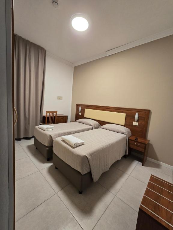Un dormitorio con dos camas y una mesa. en Hotel Helios Beach, en Milano Marittima