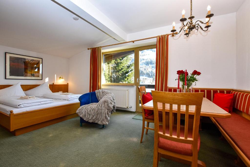 a hotel room with a bed and a table and chairs at Appartements by Hotel-Garni Austria in Westendorf