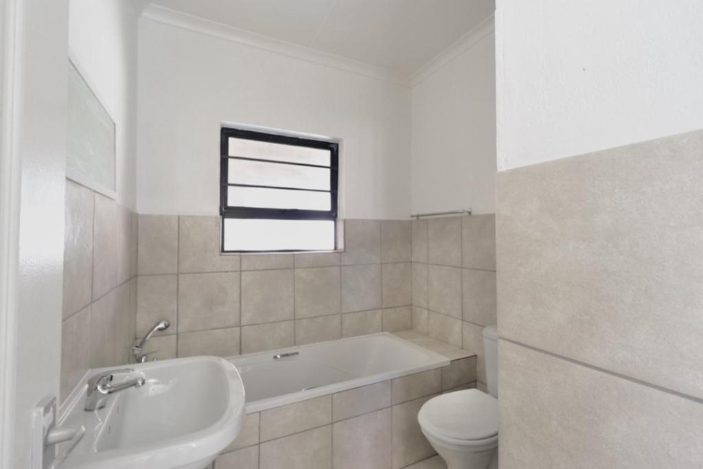 a bathroom with a tub and a toilet and a sink at Cloveridge 104 in Benoni