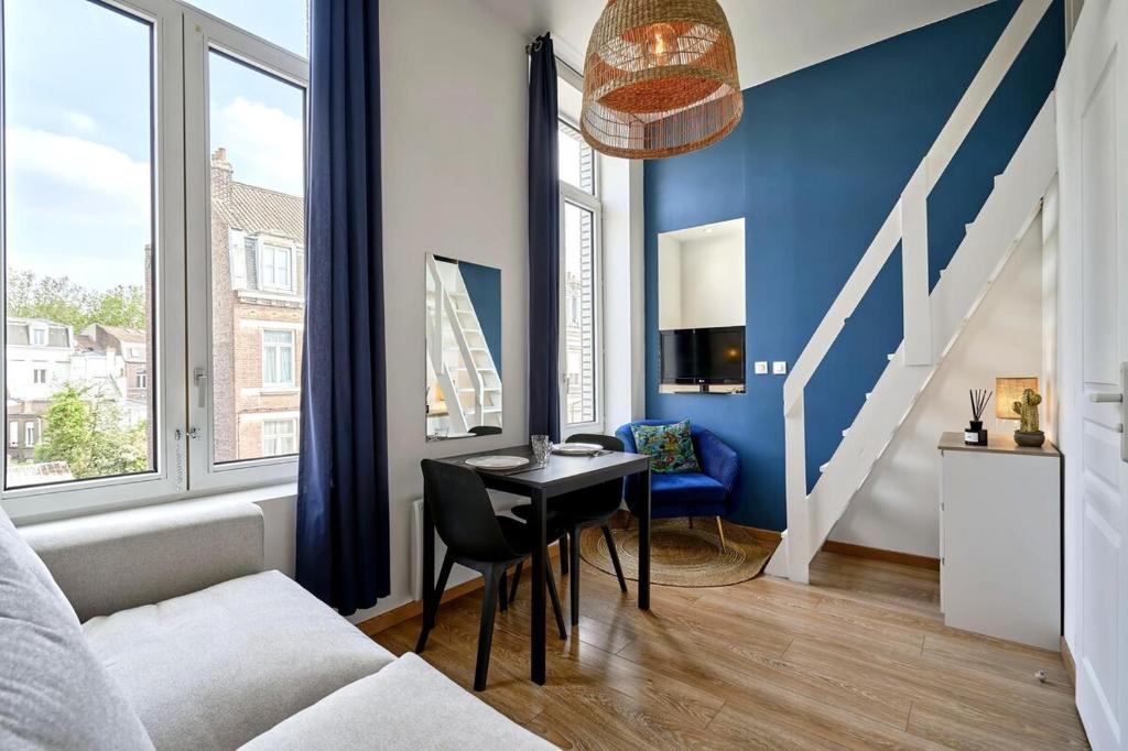 un salon avec une table et un mur bleu dans l'établissement Lille Centre Studio, à Lille