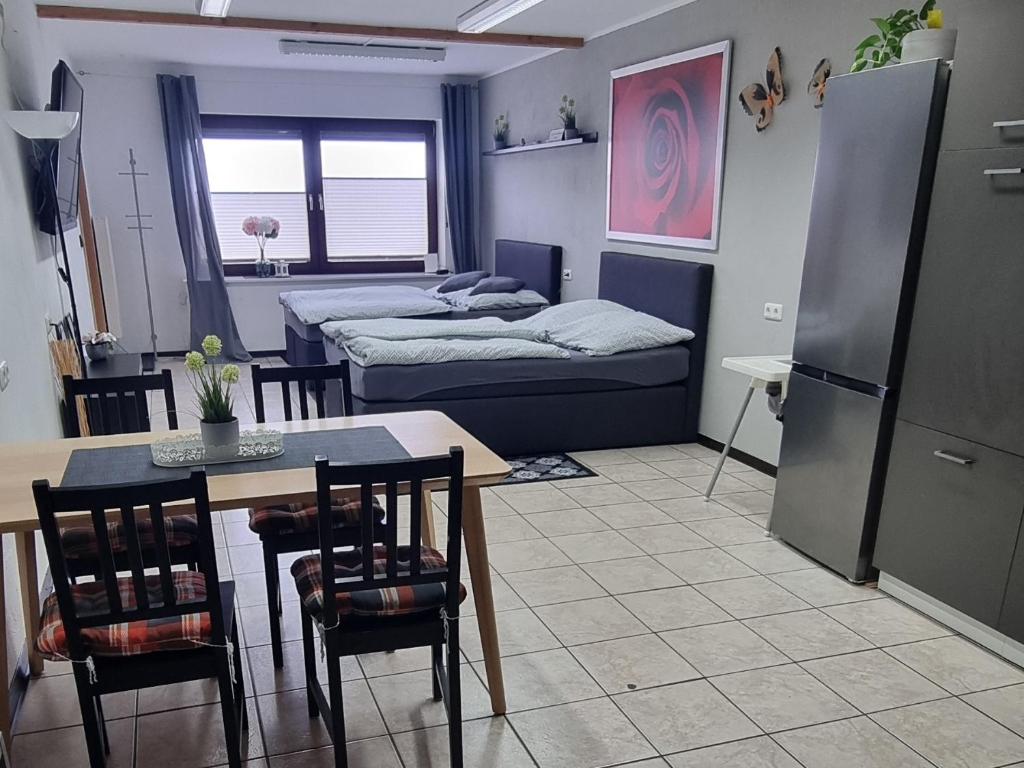 a room with a kitchen and a table and a bed at Ferienwohnung beim Nationalpark Eifel in Nideggen