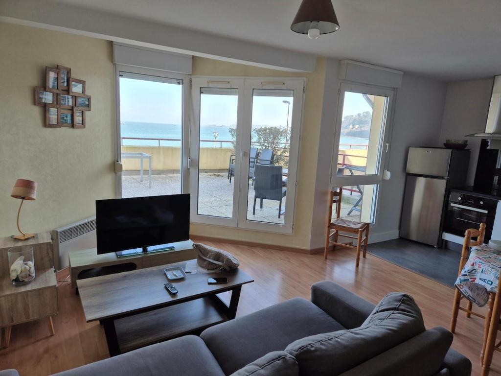 un salon avec un canapé et une table dans l'établissement Plage et terrasse à vos pieds, à Perros-Guirec