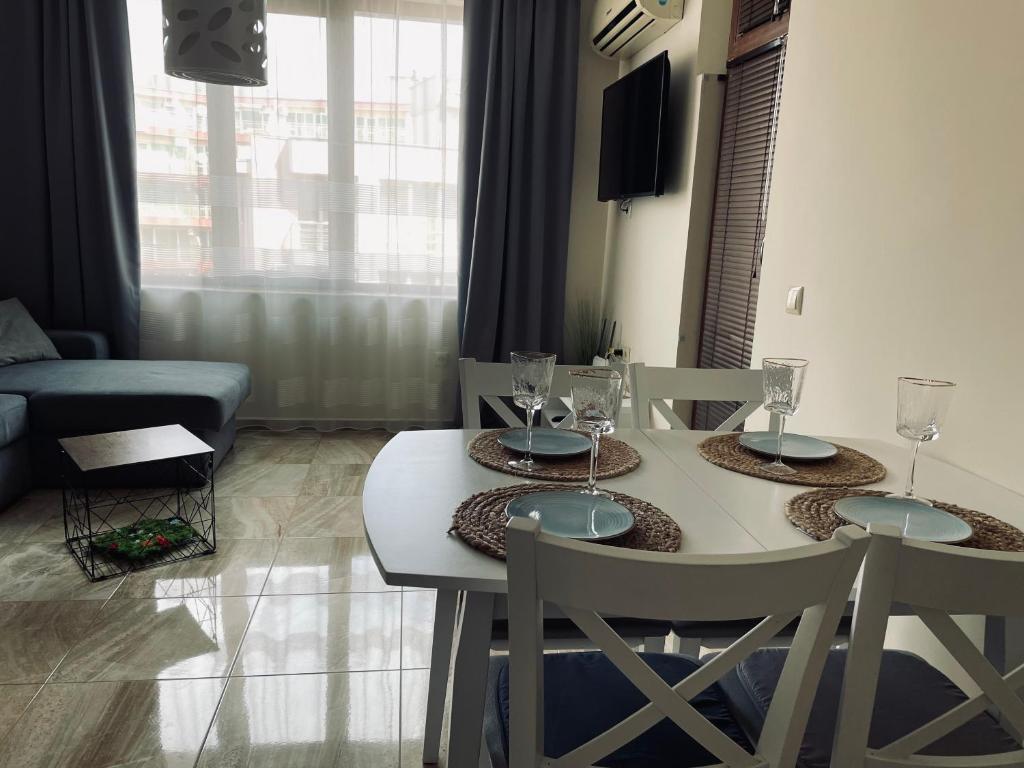 a dining room with a table and chairs with wine glasses at Beach Residence Pomorie in Pomorie
