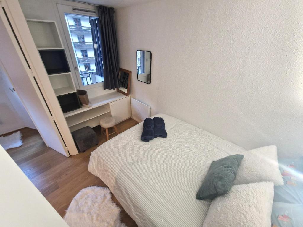 une chambre avec un lit blanc et une fenêtre dans l'établissement Appartement Cosy, Vue MontBlanc, Chamonix Centre, à Chamonix-Mont-Blanc