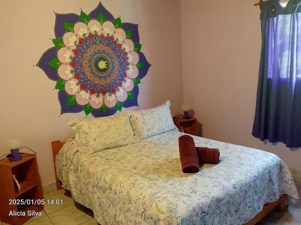 1 dormitorio con 1 cama con un mandala grande en la pared en Cabañas Alegría del Lago, en Lago Puelo