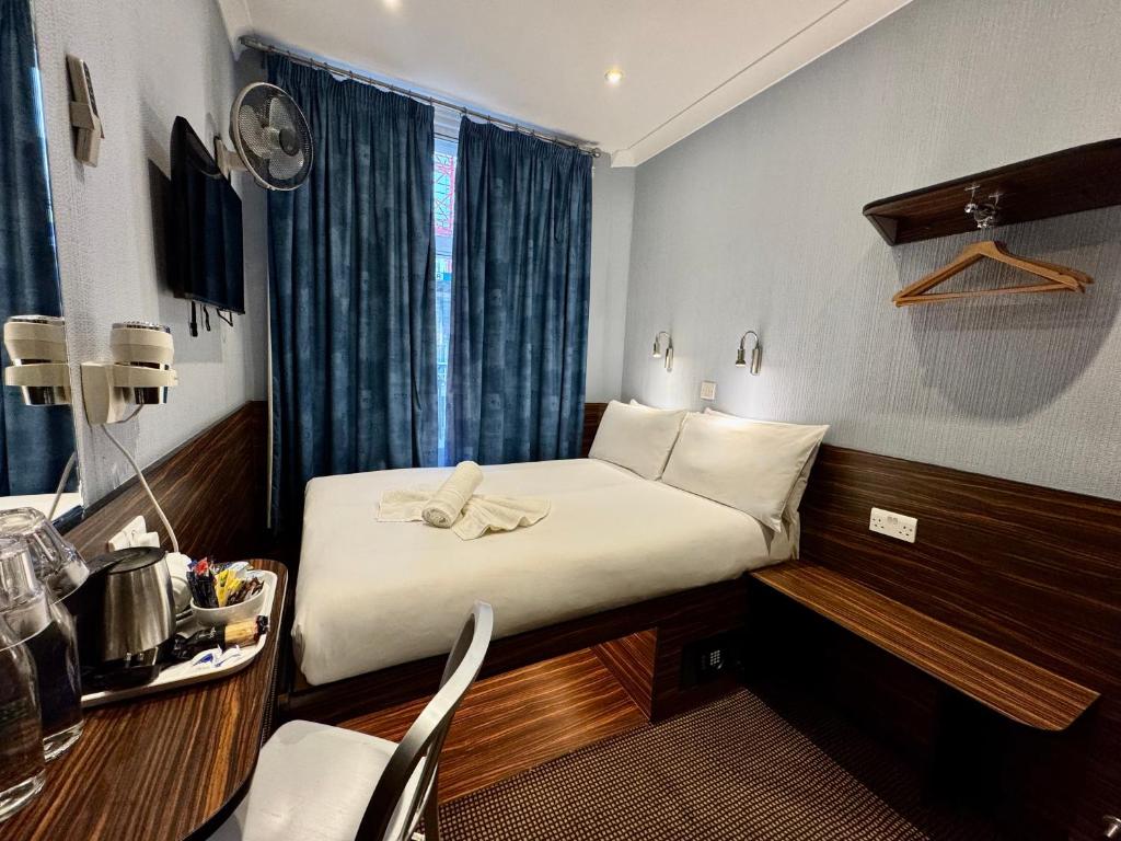 a hotel room with a bed and a table and chairs at Crestfield Hotel in London