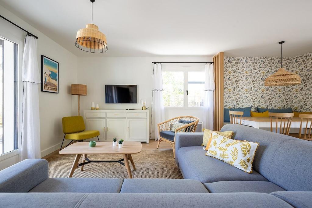 un salon avec un canapé bleu et une table dans l'établissement Villas Indigo 40 personnes, à La Teste-de-Buch