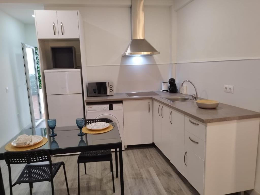 a kitchen with white cabinets and a table and chairs at Apto Estudio I Santa Clara Centro in Antequera