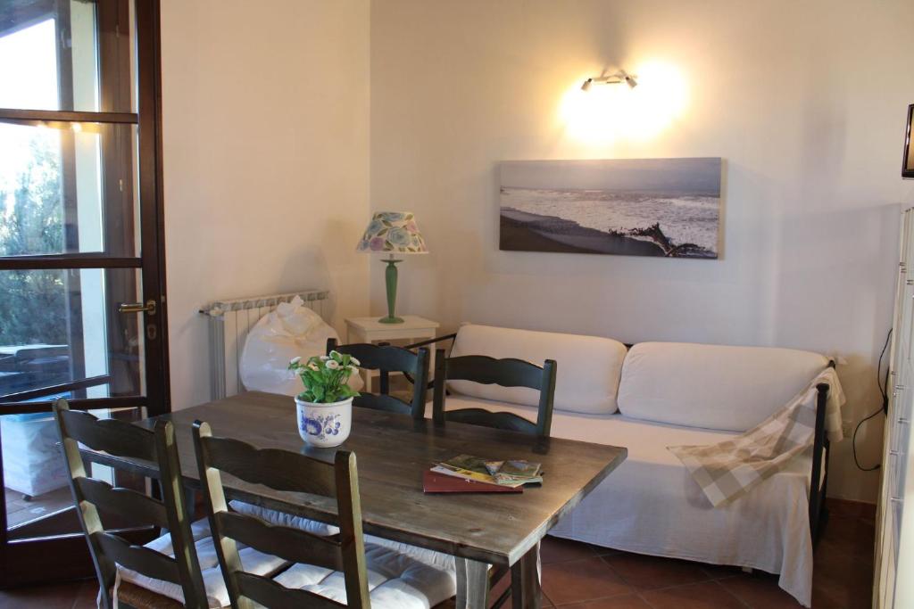 salon ze stołem i kanapą w obiekcie Casa "Ale" con piscina comune e bellissimo giardino a 5 minuti dal mare w mieście Cecina
