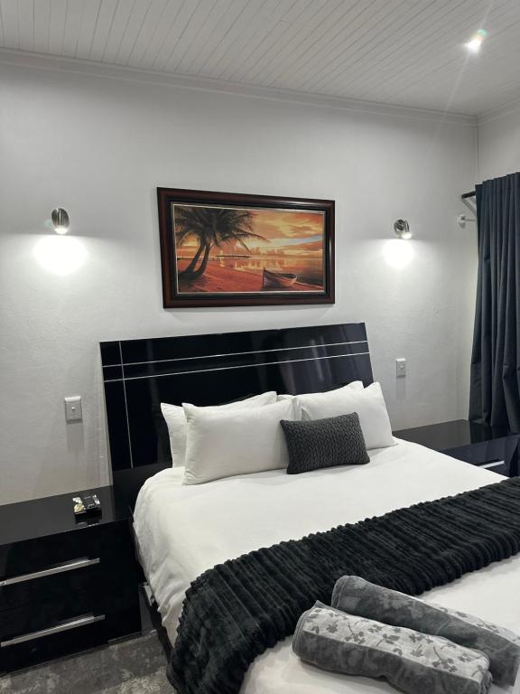 1 dormitorio con 1 cama blanca grande y cabecero negro en At JayRose, en Kimberley