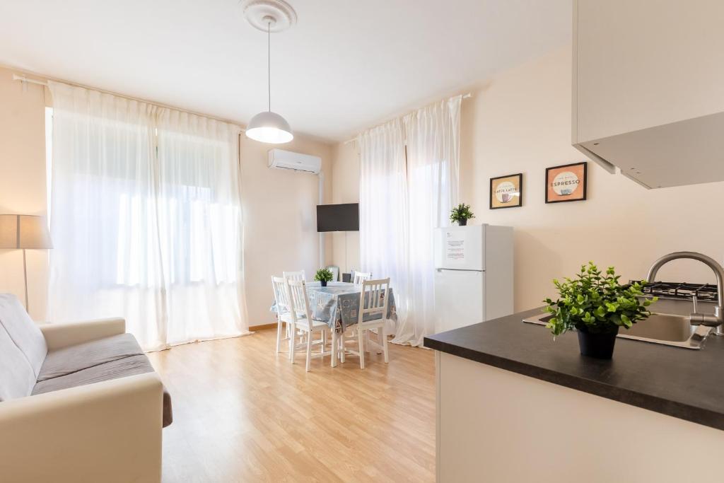 a kitchen and a living room with a table at Casa Vacanze Da Leo in Acilia