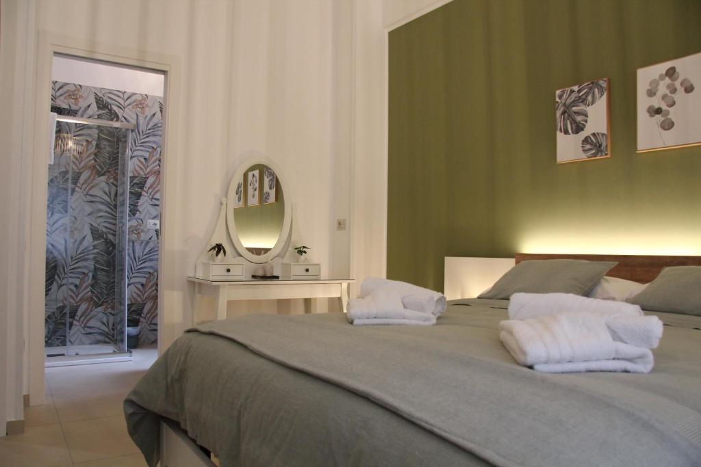 サレルノにあるNina Suitesの大きなベッドと鏡のある寝室
