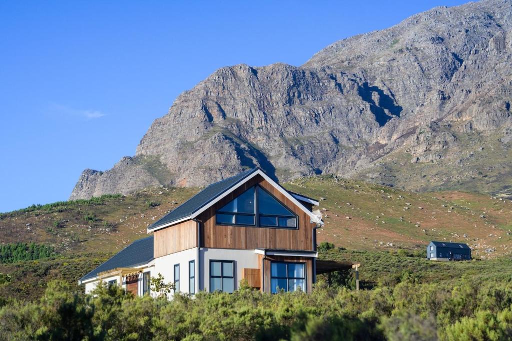 a house on a hill with a mountain in the background at Breedekloof Kajuit in Romansrivier
