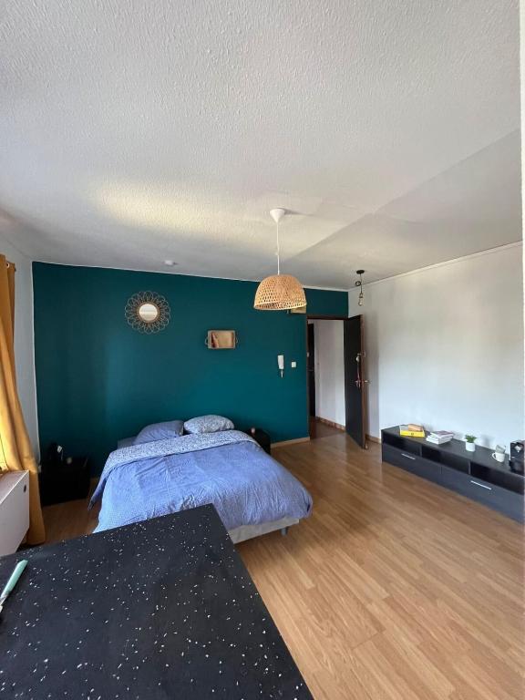 une chambre avec un lit et un mur végétal dans l'établissement TORINO - Appartement cozy, à Sarrebourg