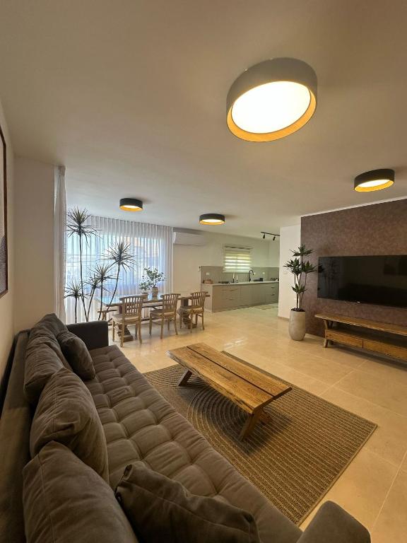 a living room with a large couch and a table at Ocean view - מול הים in Nahariyya
