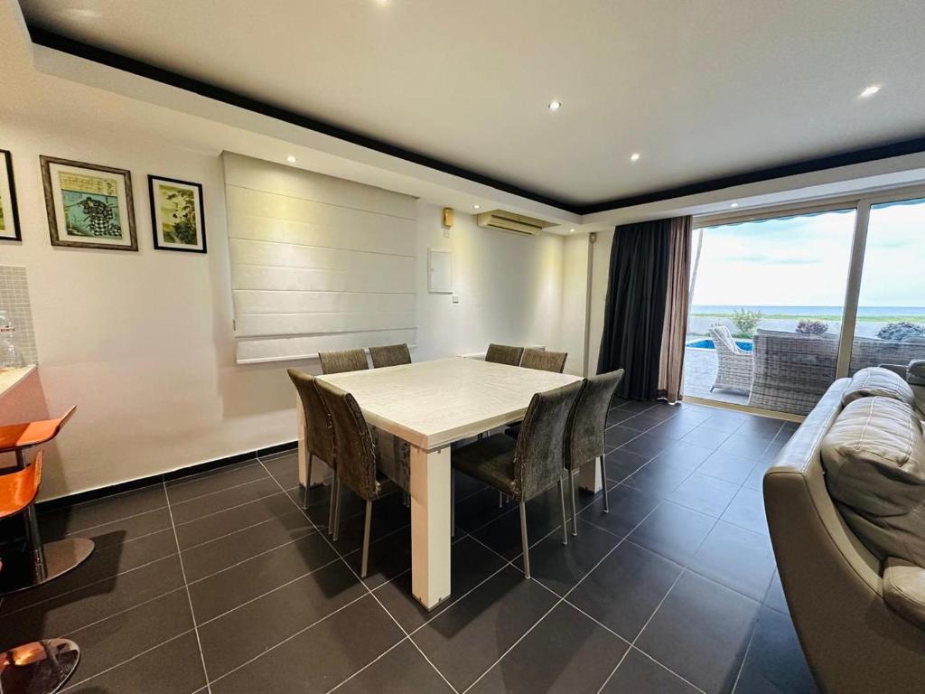 a dining room with a table and chairs and a couch at Villa Eva in Mazotos