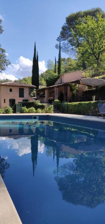 une piscine avec de l'eau bleue devant une maison dans l'établissement Le Mas St Pierre, à Aix-en-Provence