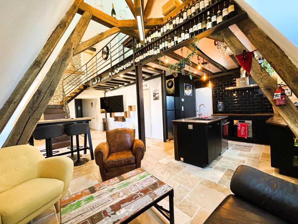 un soggiorno con una scala, un tavolo e delle sedie di Résidence du Palais a Bourges
