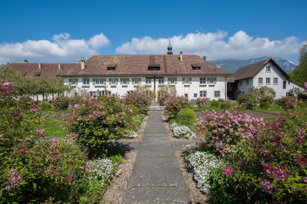 un giardino fiorito di fronte a un edificio bianco di Klosterherberge Solothurn Self Check-in a Solothurn