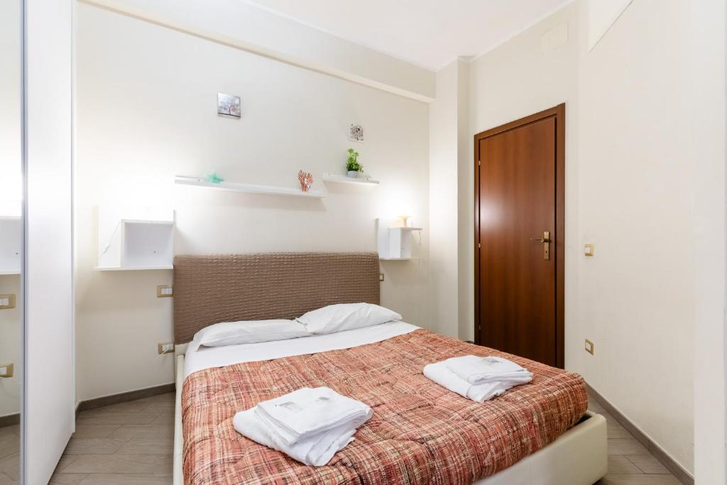 a bedroom with a bed with two towels on it at Il Vascello by ACS HOLIDAYS in Lido di Ostia