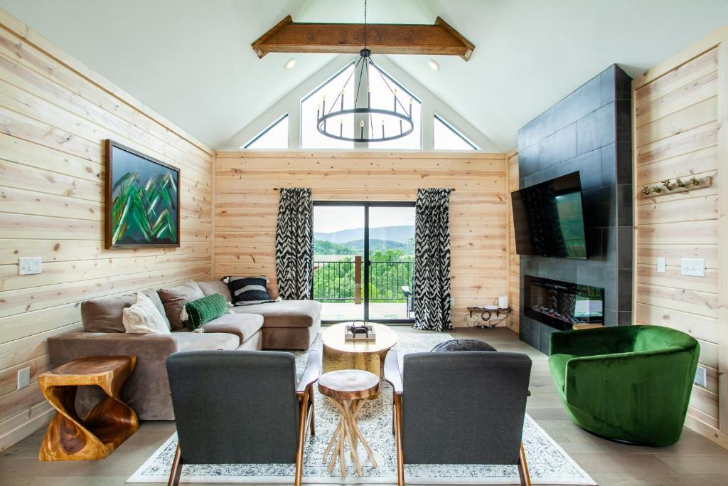ein Wohnzimmer mit Couch und Stühlen in der Unterkunft Bearly Haus -Views, Hot Tub, Pool & Xbox! in Pigeon Forge
