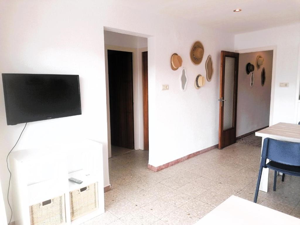 ロザスにあるGlobal Immo 3355 Solanaの壁に薄型テレビが取り付けられたリビングルーム