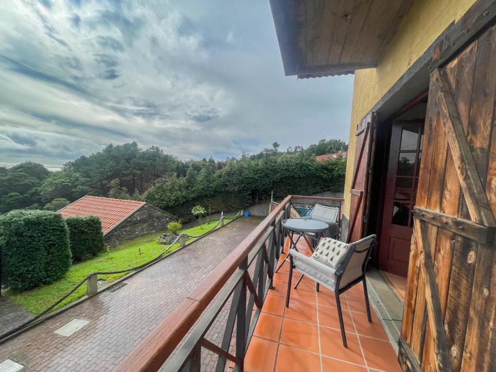 Un balcón con una silla y una mesa. en Petras Madeira Hideaway, en Santo da Serra