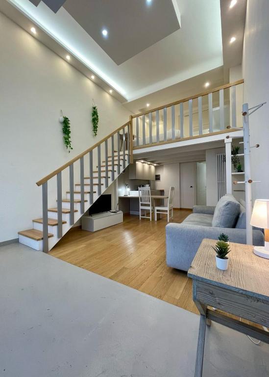 a living room with a staircase and a couch at BeCO Moscova District Loft in Milan