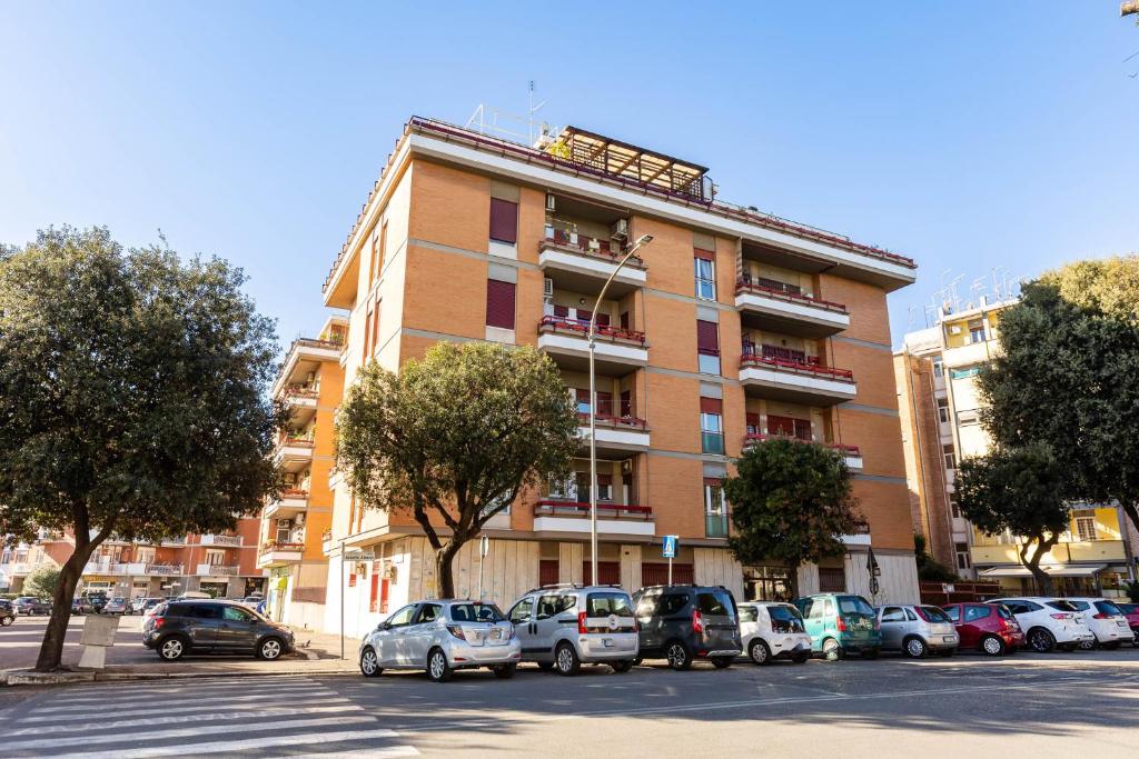 duży budynek z samochodami zaparkowanymi na parkingu w obiekcie Casa Vacanze La Casetta w mieście Lido di Ostia