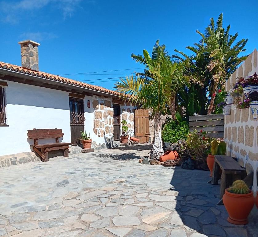 a courtyard of a house with a bench and trees at Renllon in Lomo de Arico