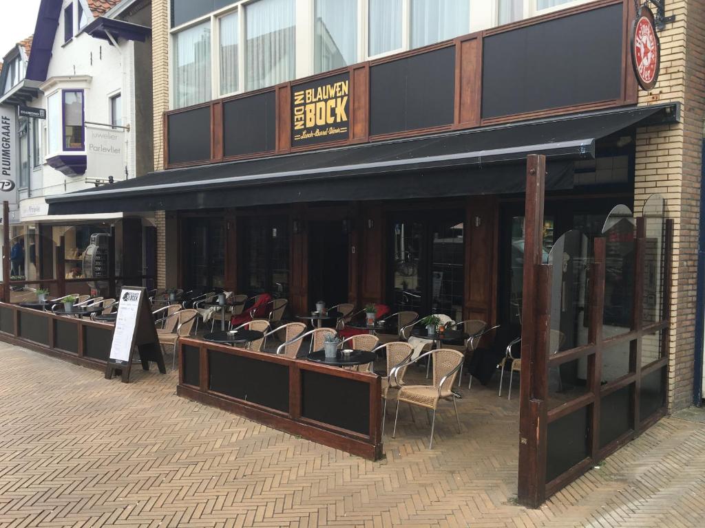 ein Restaurant mit Tischen und Stühlen außerhalb eines Gebäudes in der Unterkunft Beach Hotel Katwijk in Katwijk