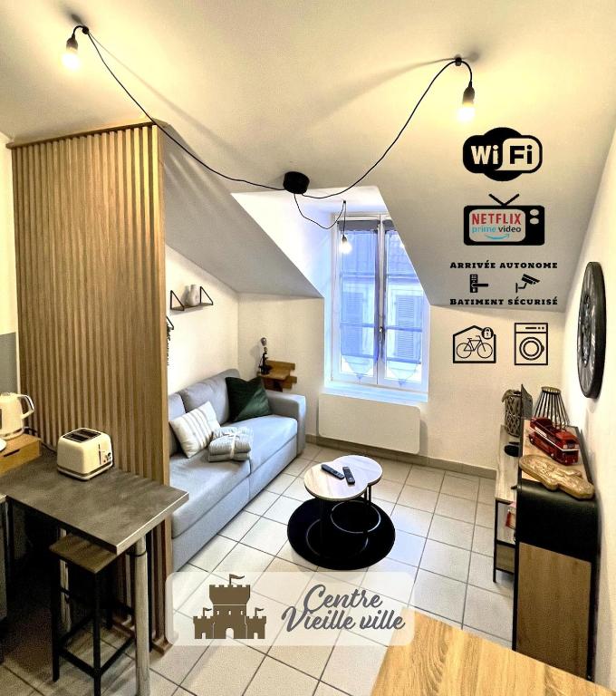 a living room with a couch and a table at Charmant appart T2 tout équipé in Montbéliard